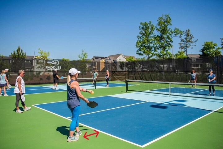 Người chơi đứng sau đường baseline để giao bóng trên sân pickleball