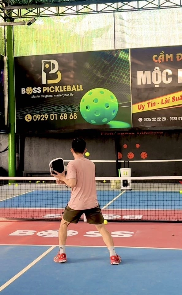 Người chơi đang tập với máy bắn bóng tại sân Boss Pickleball